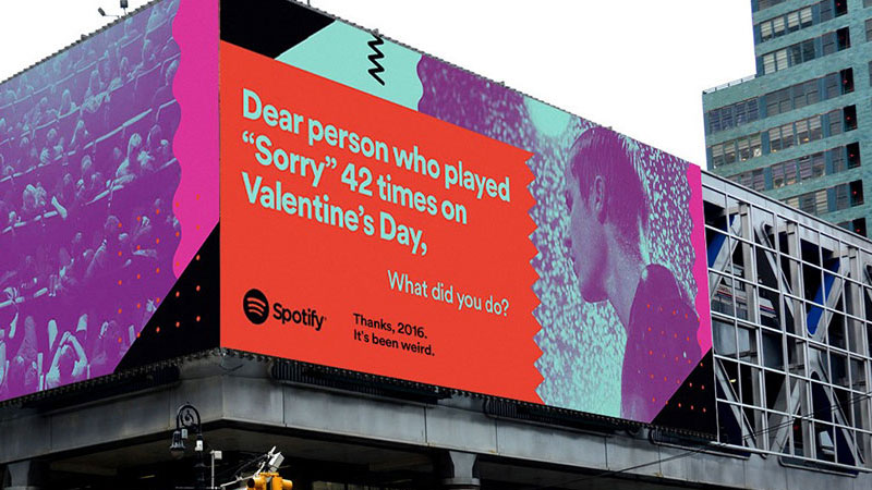 Spotify billboard advertising featuring a humorous message addressing a user who played 'Sorry' 42 times on Valentine's Day, part of their 'Thanks, 2016. It's been weird.' campaign, displayed on a large urban billboard with vibrant colors and playful design.