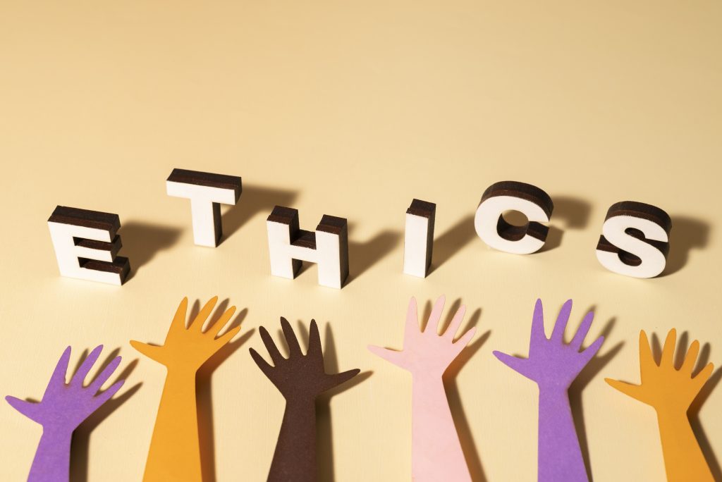 Colorful hands reaching up towards 3D letters spelling 'ETHICS,' symbolizing the importance of ethical marketing practices and inclusive business values.