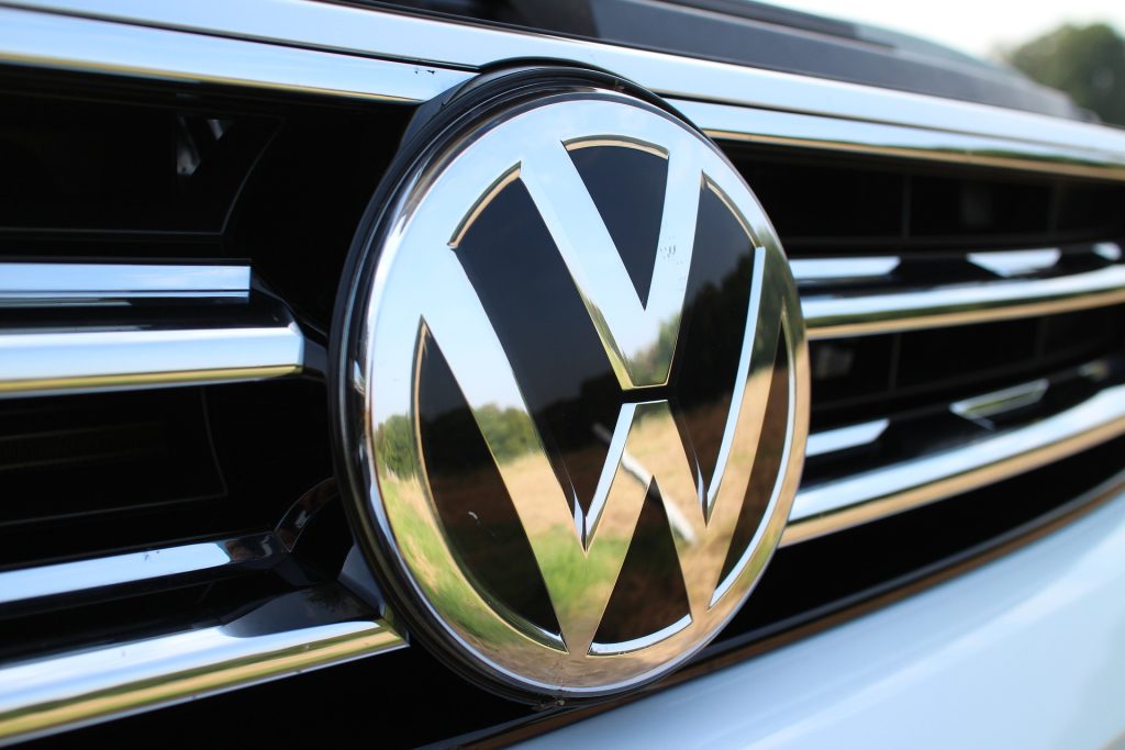A close up shot of the V W Volkswagen logo on the front of a car