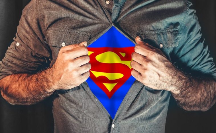 A man opens his shirt to reveal a Superman ‘S’ emblem underneath, symbolizing the power and impact of a marketing agency in Malaysia